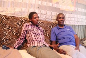 Mary Wangare, left and her Mother Pauline Mwihaki sitting on a couch at their home in Mukuru kwa Njenga informal settlement in Nairobi.