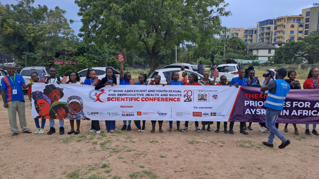 youths posing with a street banner for the event